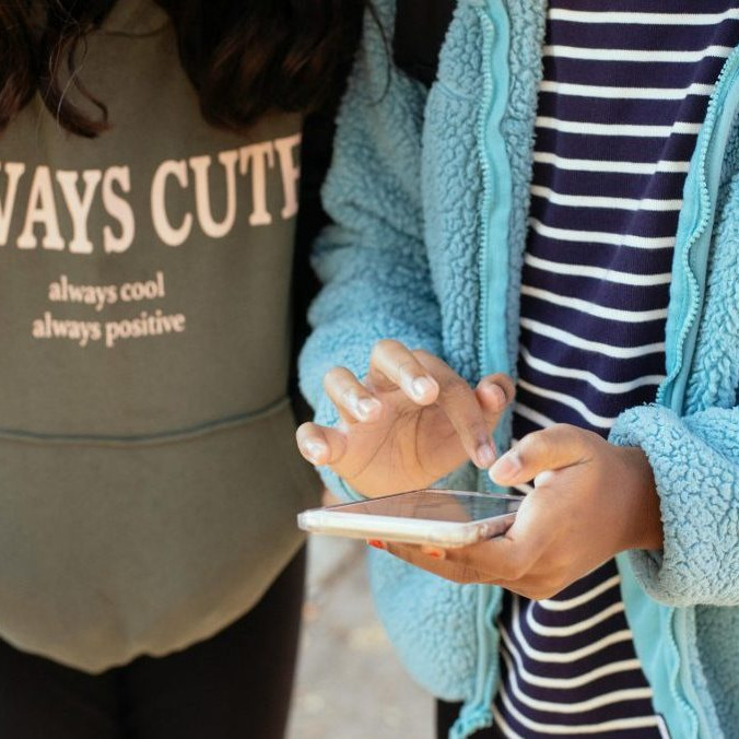 Na ilustračnej snímke dve deti s telefónom.