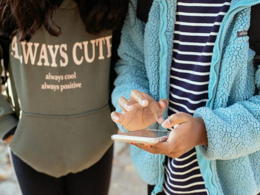 Na ilustračnej snímke dve deti s telefónom.