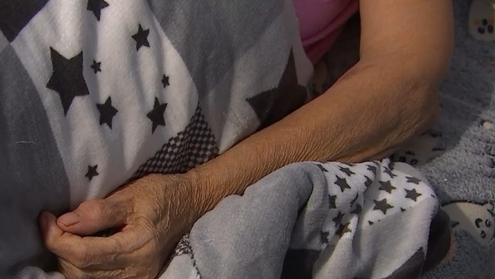 Na ilustračnej snímke ruka seniorky ležiacej v posteli.