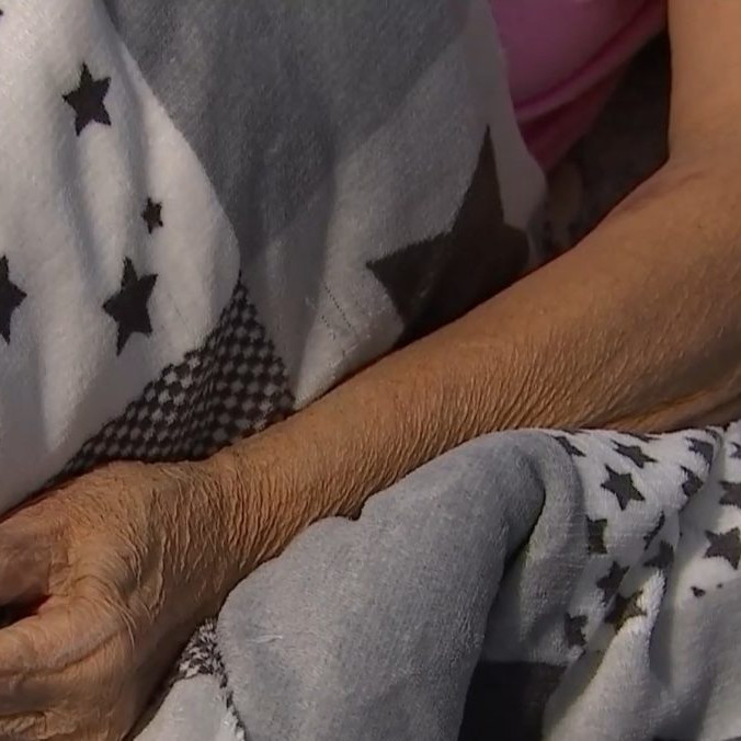 Na ilustračnej snímke ruka seniorky ležiacej v posteli.