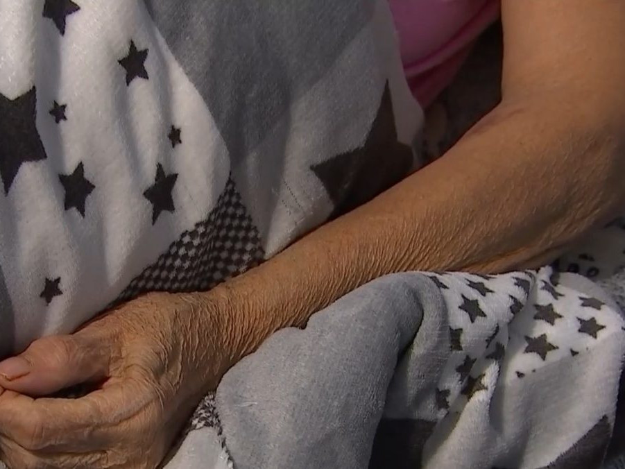 Na ilustračnej snímke ruka seniorky ležiacej v posteli.