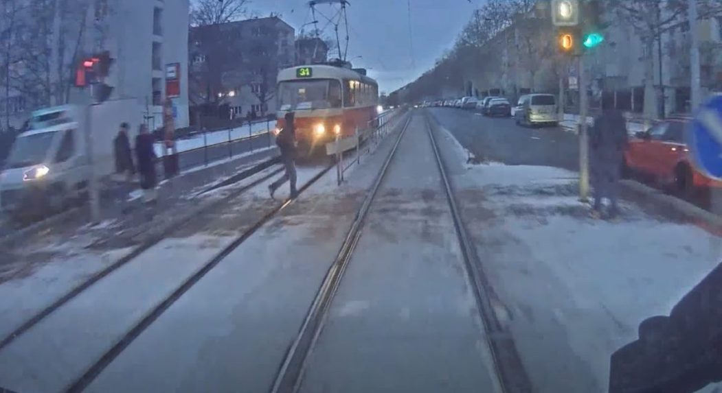 Na snímke chlapec kráča po električkovej trati.