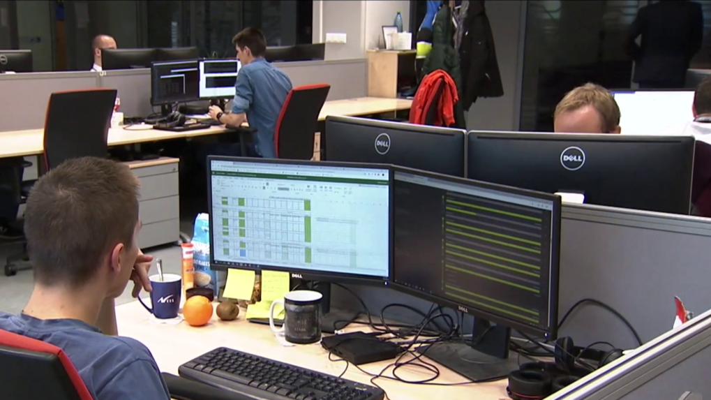 Na snímke v kancelárii ľudia pracujú za počítačmi.