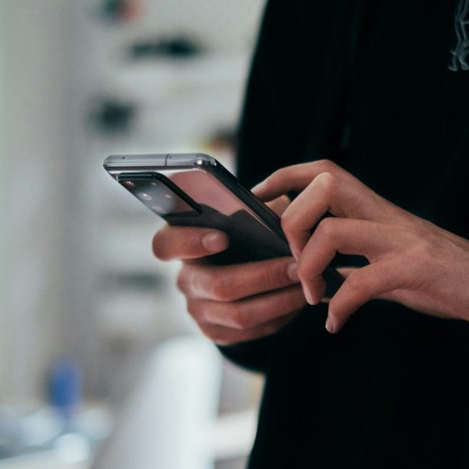 Muž drží v ruke telefón.