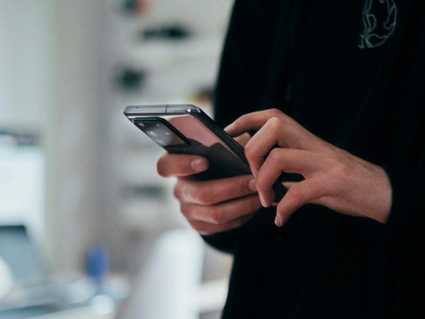 Muž drží v ruke telefón.