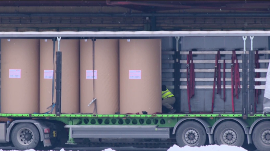 Na snímke je osoba na otvorenom návese nákladného vozidla.