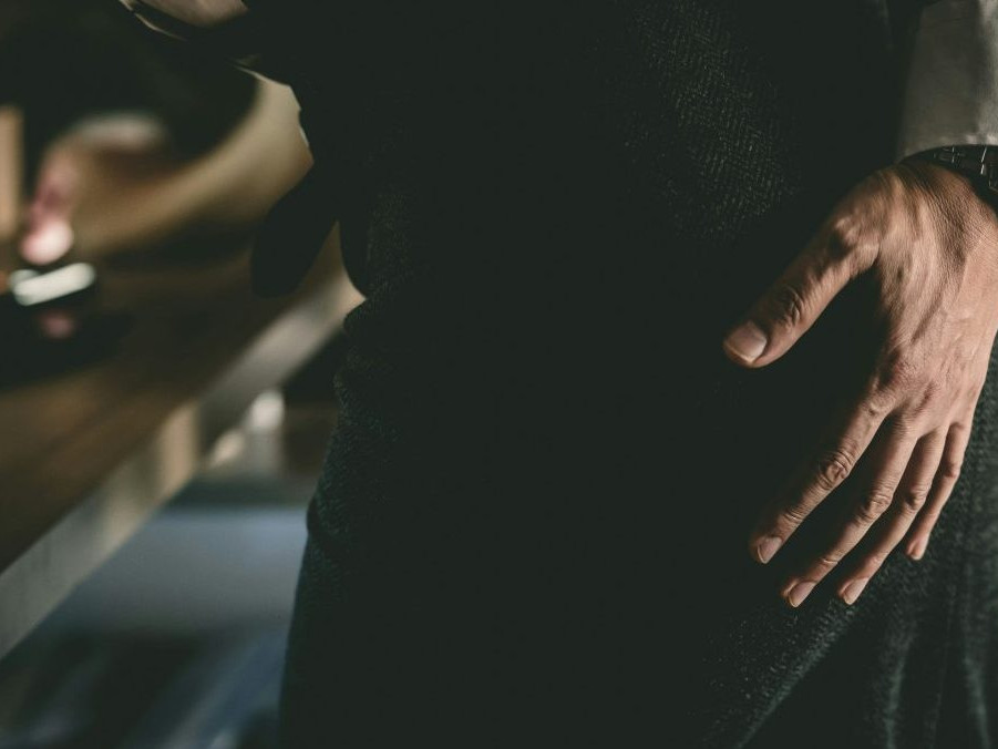 Na ilustračnej snímke mužská ruka na ženskom pozadí.