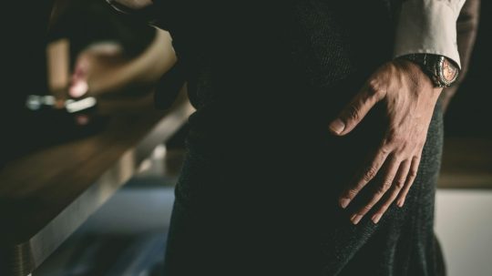 Na ilustračnej snímke mužská ruka na ženskom pozadí.