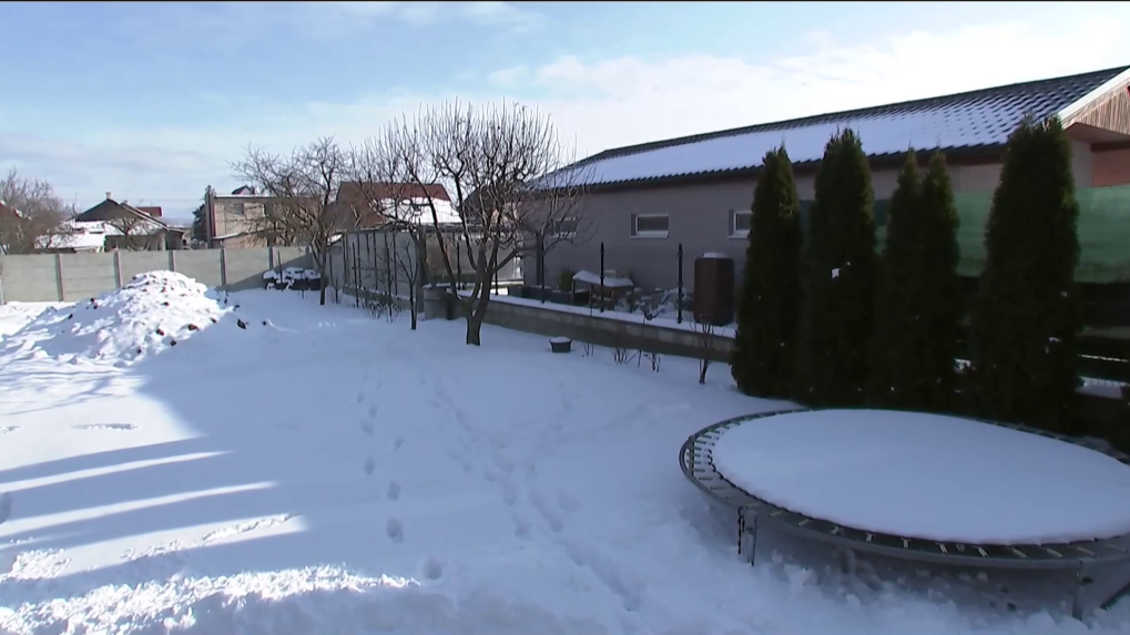 Na snímke zasnežené pozemky, medzi nimi pletivový plot.