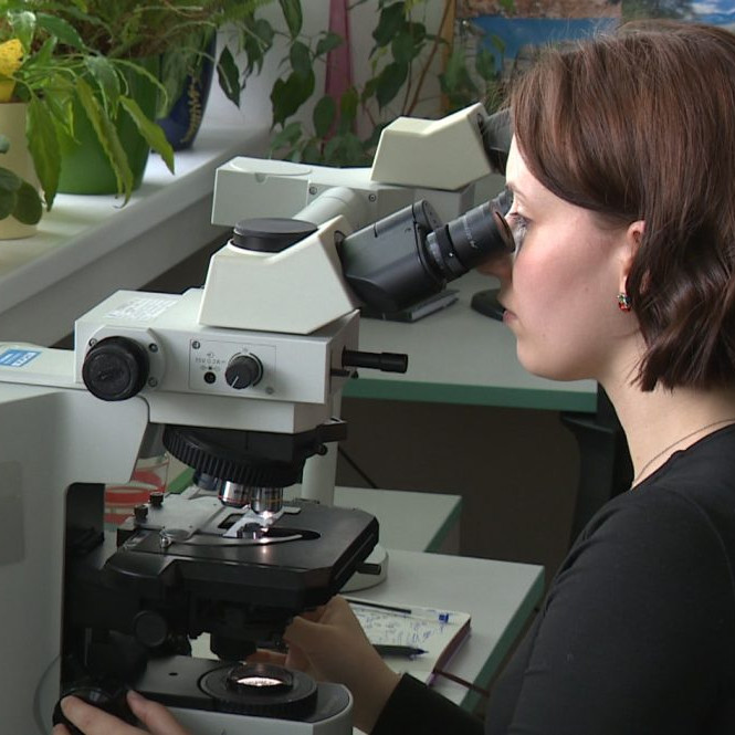 žena za mikroskopom