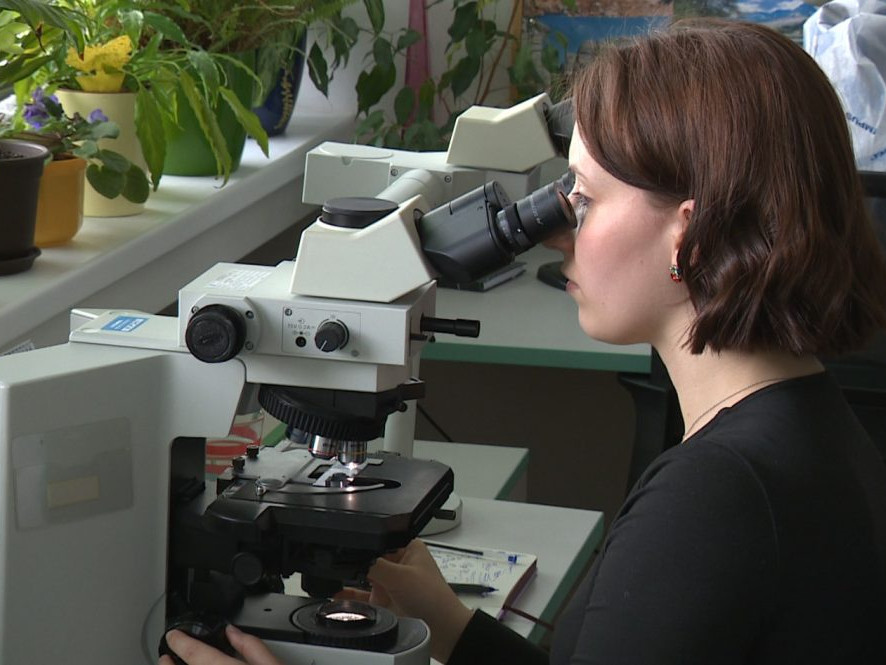 žena za mikroskopom