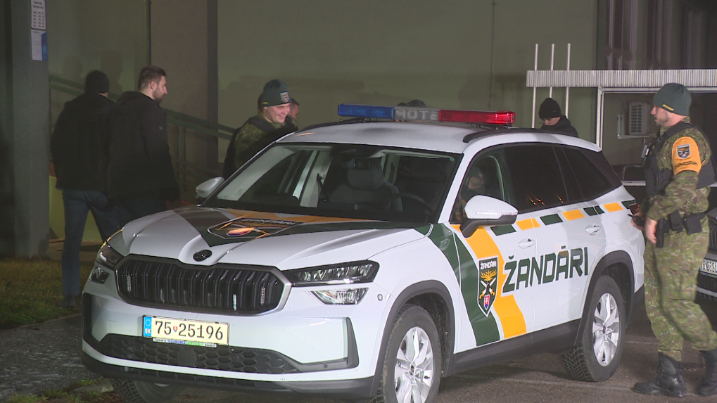 Na snímke sú žandári okolo žandárskeho auta.