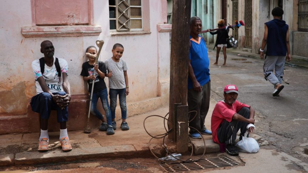 Ľudia sa počas výpadku prúdu v Havane zdržiavajú na chodníku.
