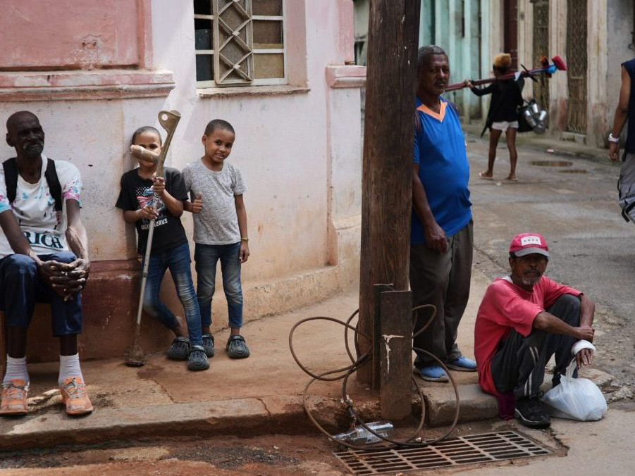 Ľudia sa počas výpadku prúdu v Havane zdržiavajú na chodníku.