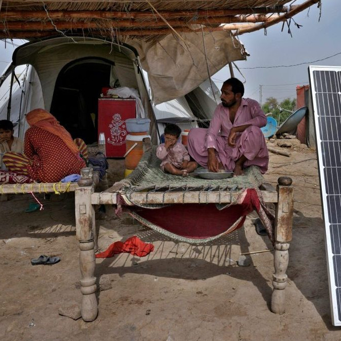 Obete povodní v Pakistane vedľa solárneho panelu.