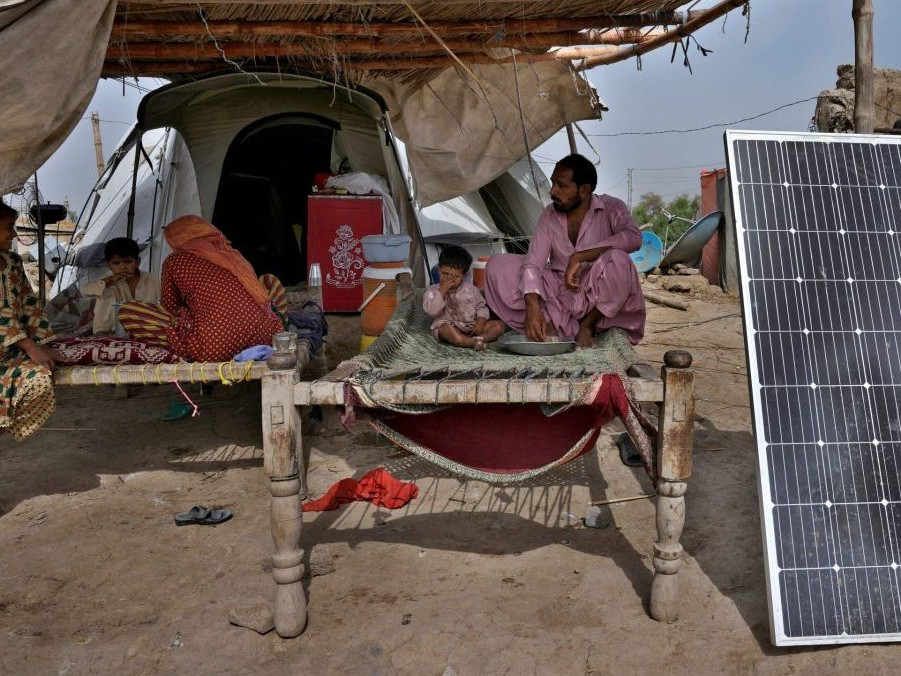 Obete povodní v Pakistane vedľa solárneho panelu.