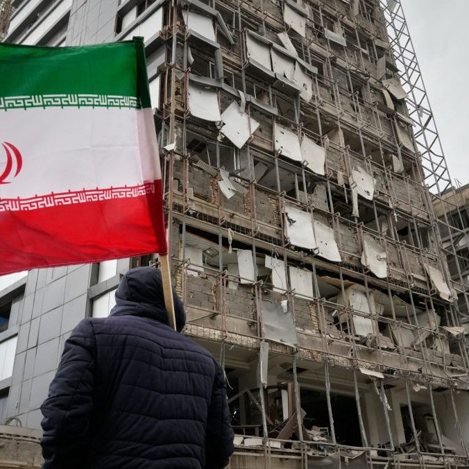 Na snímke muž drží irásnku vlajku pred nemocnicou Gándhí, ktorú poškodil útok.