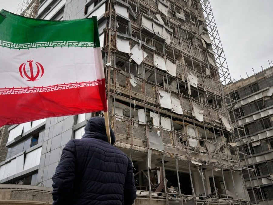 Na snímke muž drží irásnku vlajku pred nemocnicou Gándhí, ktorú poškodil útok.