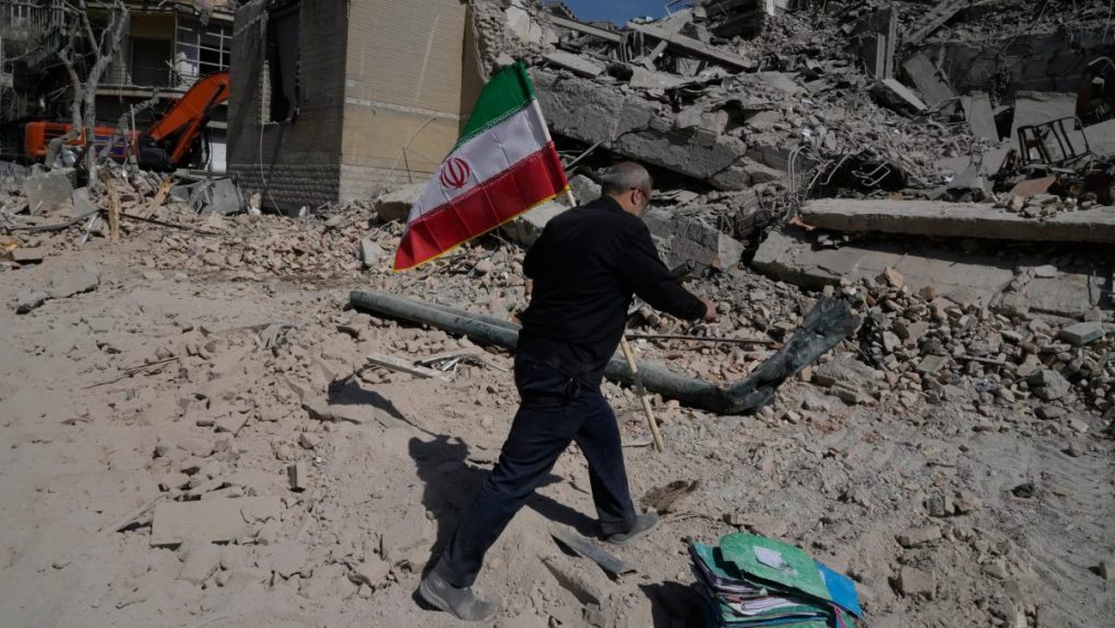 Na snímke muž drží iránsku vlajku po útoku USA a Izraela.