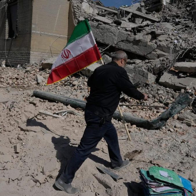 Na snímke muž drží iránsku vlajku po útoku USA a Izraela.