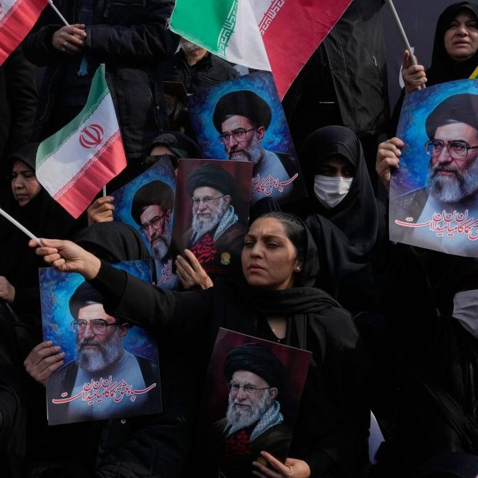 Ľudia mávajú iránskymi vlajkami.