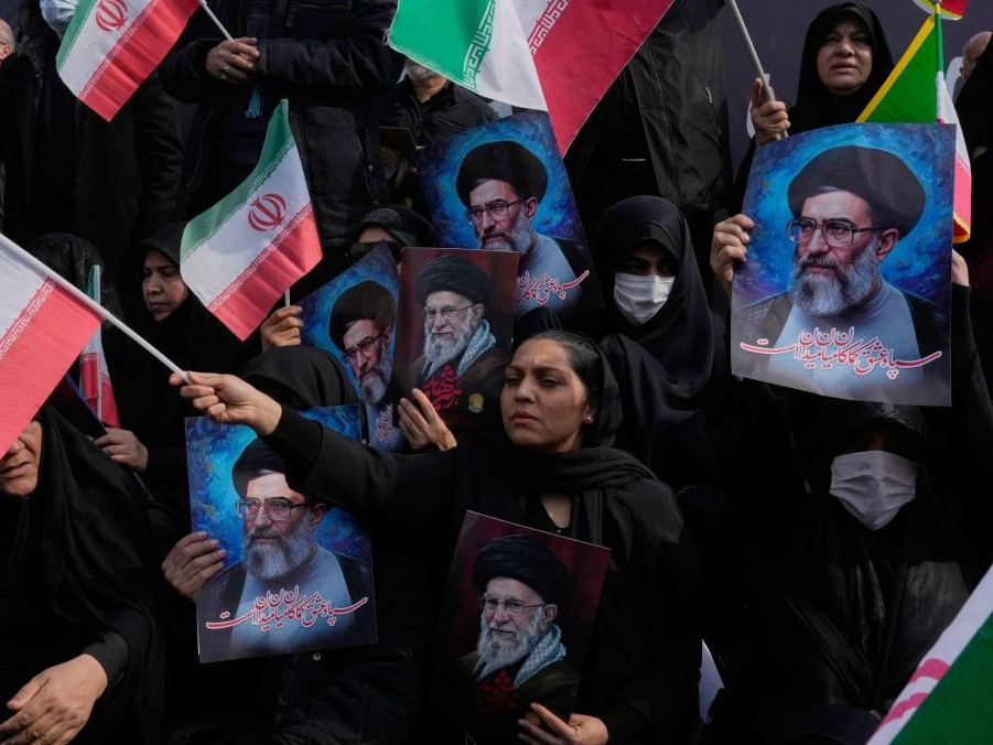 Ľudia mávajú iránskymi vlajkami.