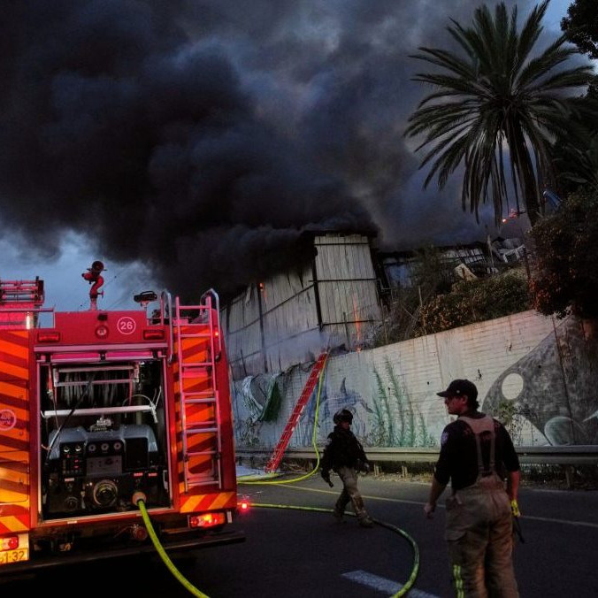 Hasiči zasahujú po leteckom útoku iránskej armády na izraelské mesto Cholon.