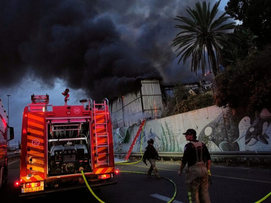 Hasiči zasahujú po leteckom útoku iránskej armády na izraelské mesto Cholon.