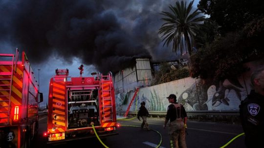 Hasiči zasahujú po leteckom útoku iránskej armády na izraelské mesto Cholon.