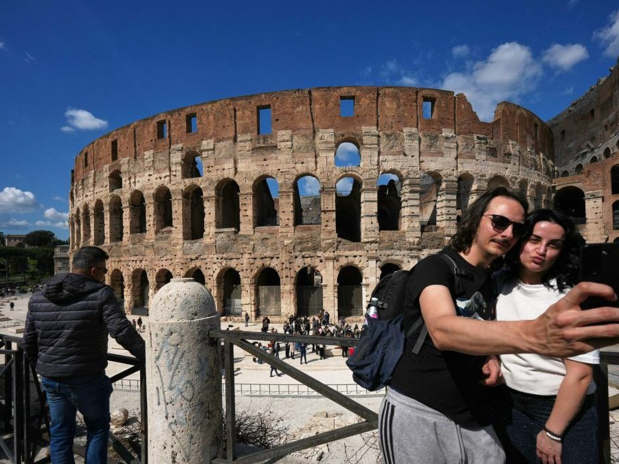 Turisti obdivujú Koloseum v Ríme.