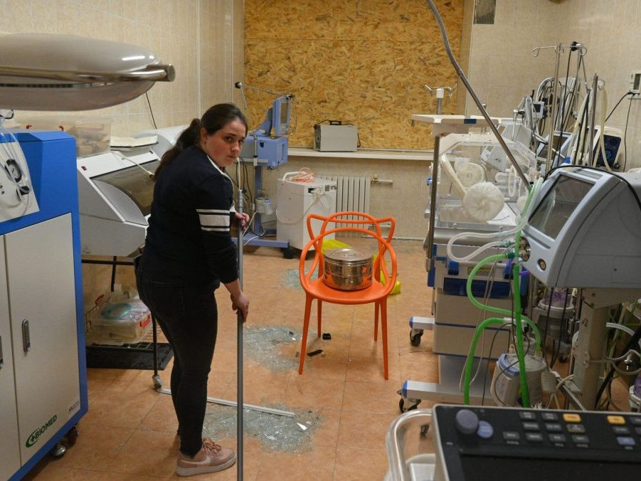 Zdravotná sestra zametá rozbité sklo z okien v pôrodnici po ruskom leteckom útoku v Odese.