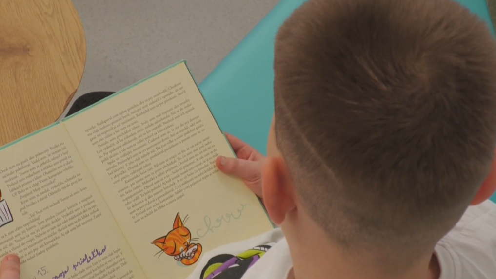 Žiak si číta knihu v relaxačnej miestnosti.