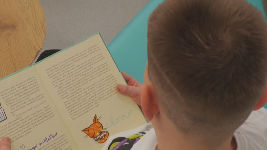 Žiak si číta knihu v relaxačnej miestnosti.