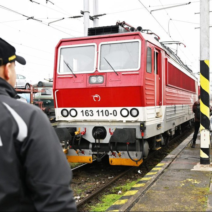 policajt stojí pred vlakom