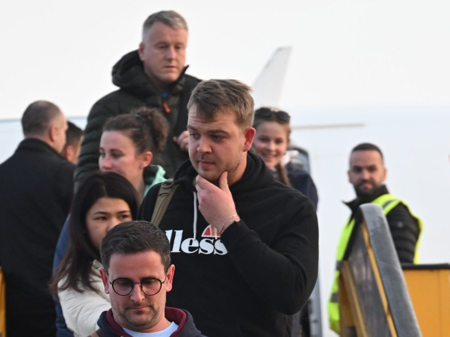 Ľudia vystupujú z repatriačného letu.