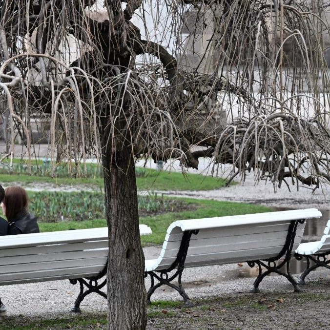 Na ilustračnej snímke pár sediaci na lavičke v parku.