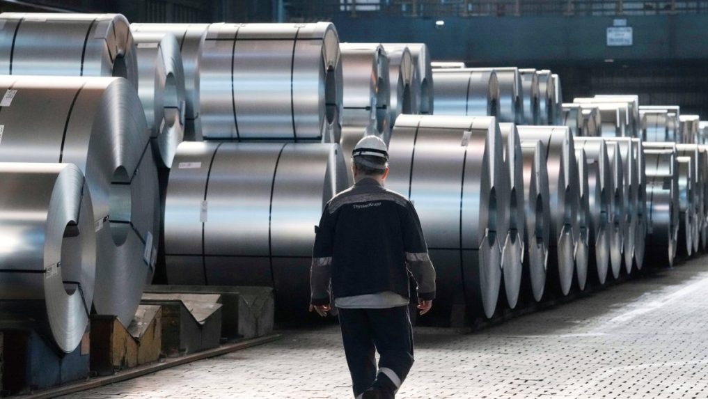 Na ilustračnej snímke oceliar kráča popri oceľových zvitkoch.