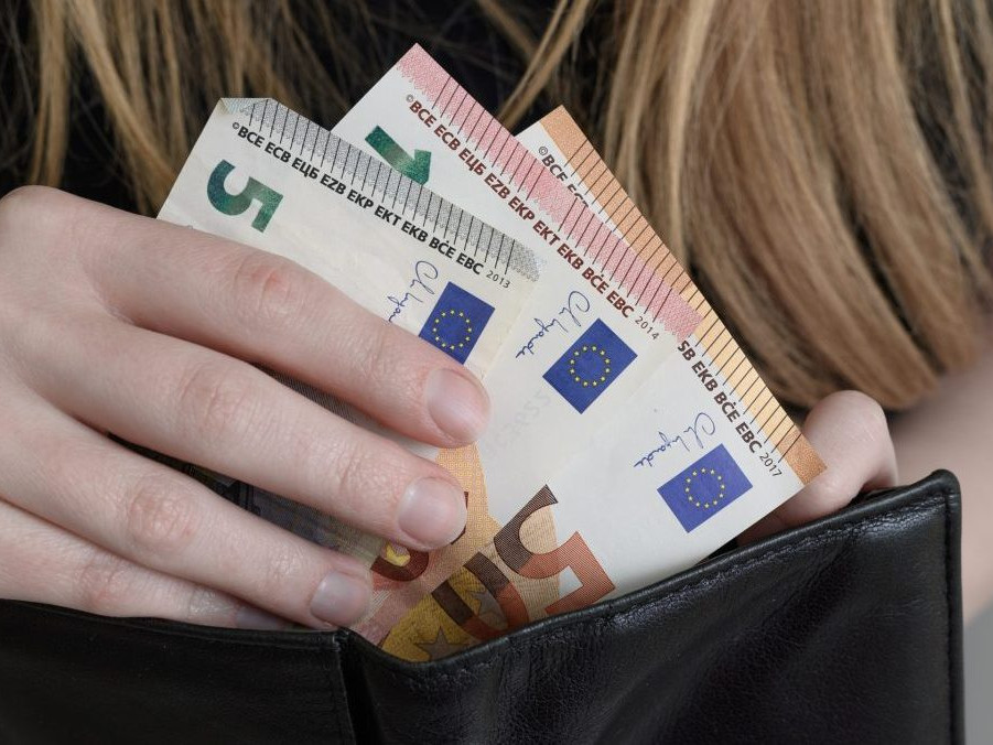 žena vkladá peniaze do peňaženky