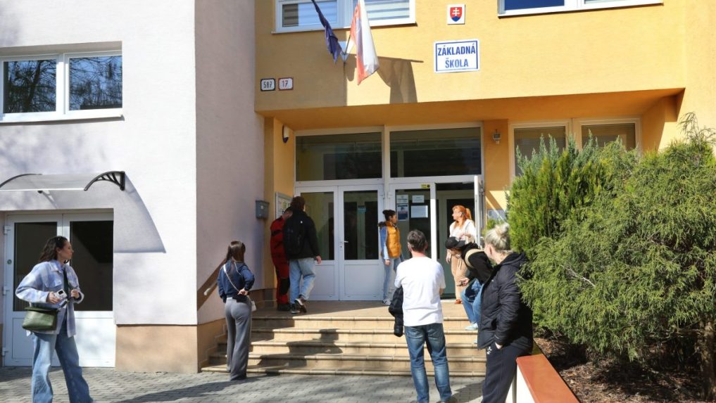 ľudia pred školou