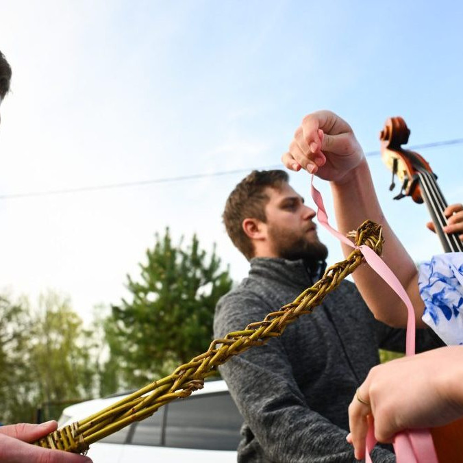 Na snímke členka folklórneho súboru Kopaničiar viaže stužku na korbáč počas šibačky.