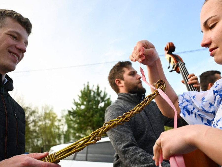Na snímke členka folklórneho súboru Kopaničiar viaže stužku na korbáč počas šibačky.