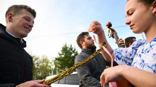 Na snímke členka folklórneho súboru Kopaničiar viaže stužku na korbáč počas šibačky.