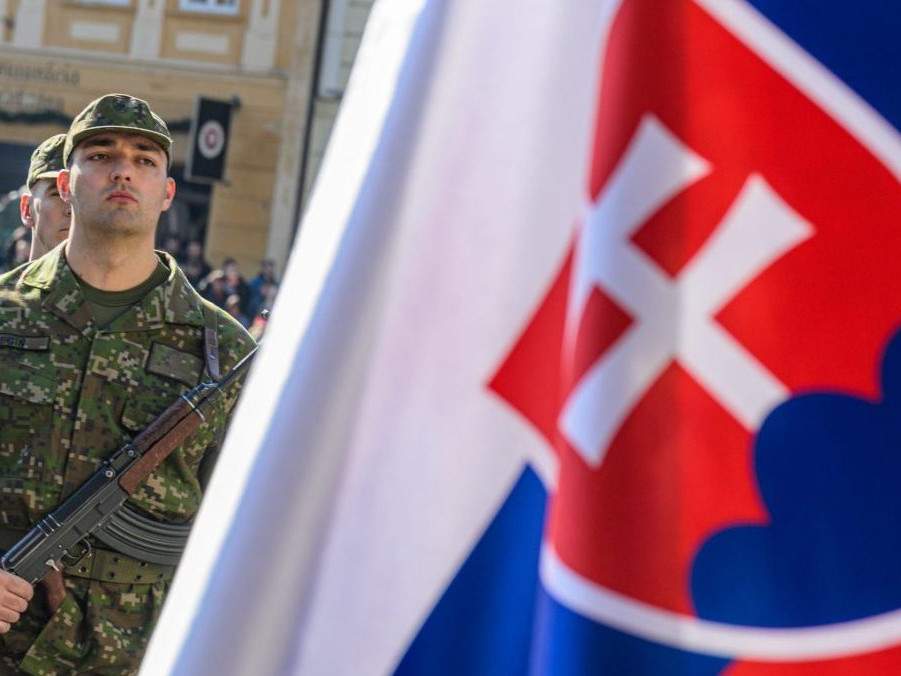 Na snímke slovenskí vojak a slovenská vlajka.