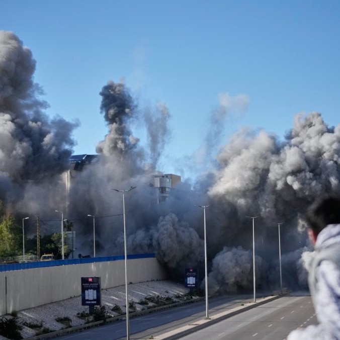 Okoloidúci sa pozerajú ako dym stúpa z miesta izraelských leteckých útokov na obytnú budovu pri ceste na letisko v Bejrúte