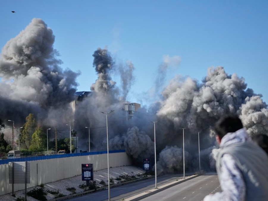 Okoloidúci sa pozerajú ako dym stúpa z miesta izraelských leteckých útokov na obytnú budovu pri ceste na letisko v Bejrúte