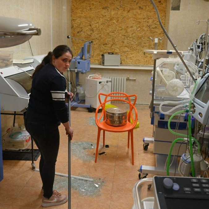 Zdravotná sestra zametá rozbité sklo z okien v pôrodnici po ruskom leteckom útoku v Odese.