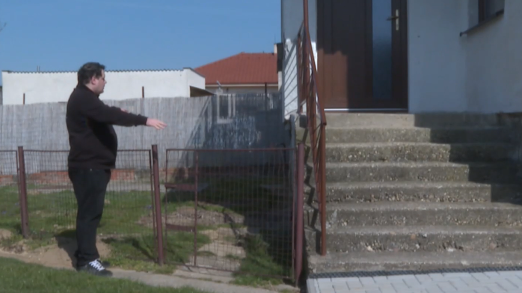 Na snímke muž stojí pred schodmi do rodinného domu.