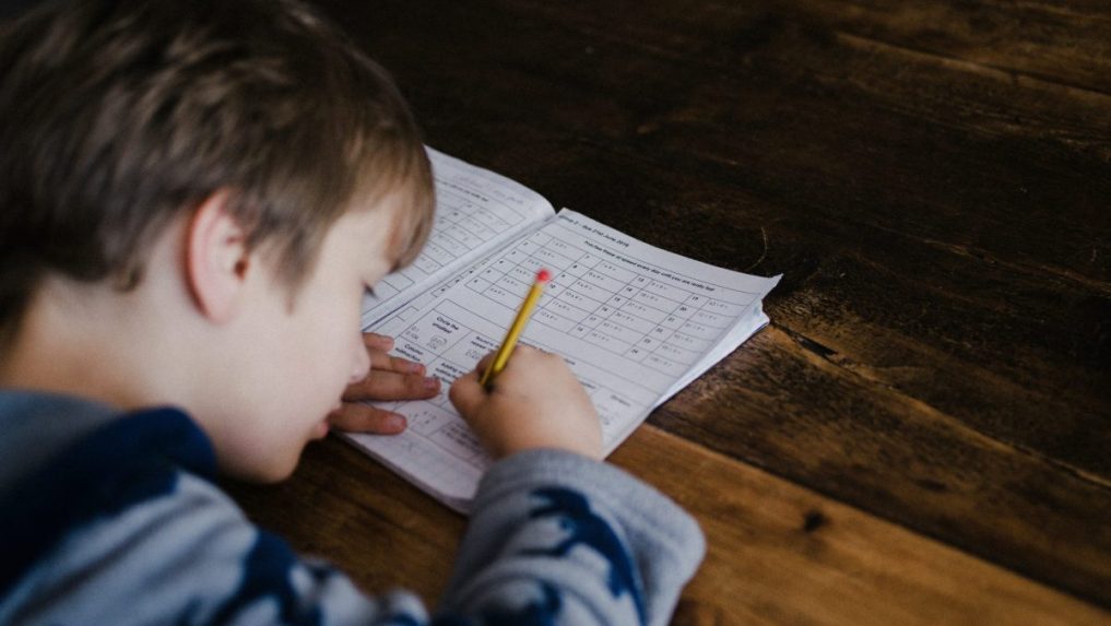 Na snímke si dieťa robí domáce úlohy.