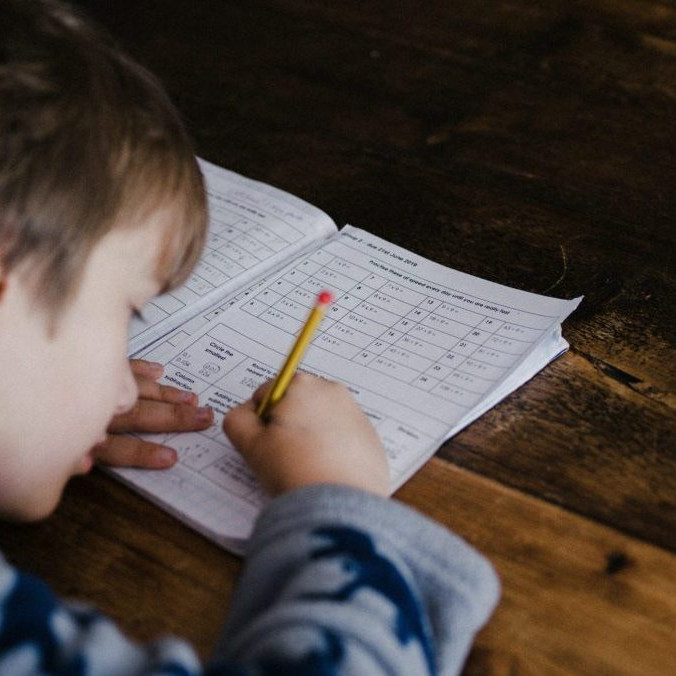 Na snímke si dieťa robí domáce úlohy.