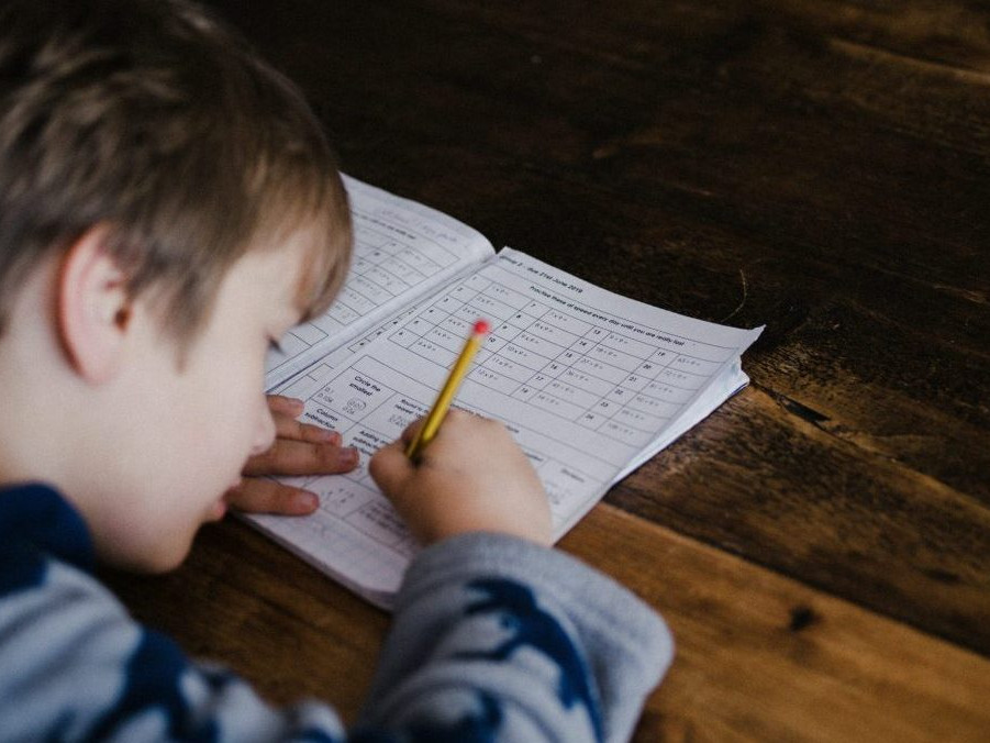 Na snímke si dieťa robí domáce úlohy.